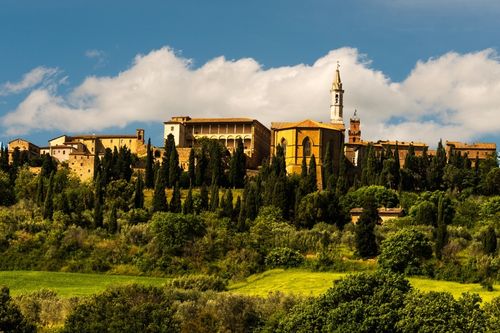 Pienza sulla collina della Val d’Orcia, circondata da cipressi e campi verdi