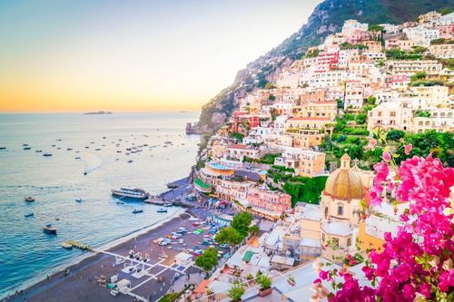 Positano vista dall’alto al tramonto, case pastello a picco sul mare e spiaggia